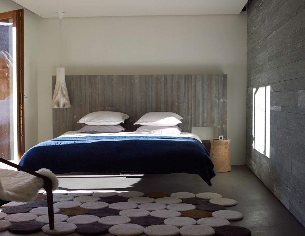 éclairer sa chambre. Dans cette atmosphère sereine, la suspension Seppo Koho de Secto Design, le tapis Circulos de Gandiablasco et le lit suspendu Fluttua de Lago.